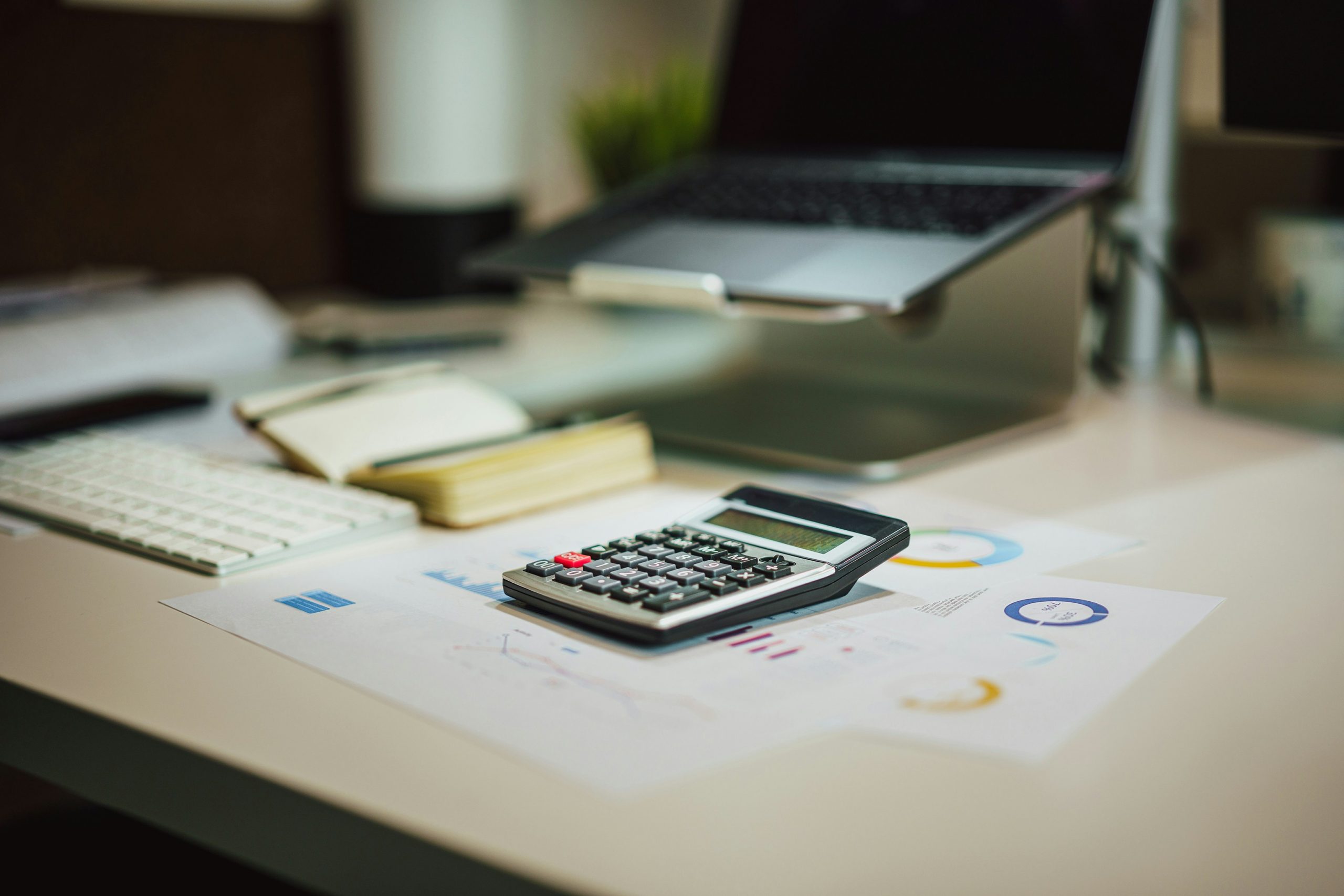 Bureau avec ordinateur, calculatrice et documents fiscaux pour la gestion de la fiscalité d’entreprise.
